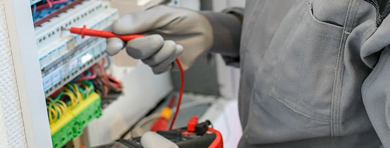Elektroniker misst Leitungen in Schaltschrank